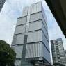 Low angle view of the Tokyo Garden Terrace Kioicho tower against a cloudy sky